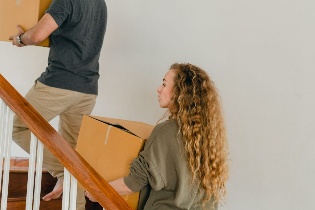 Pareja joven entrando cajas en su nuevo piso de alquiler